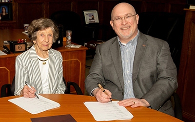 Mary W. Solomon with Michael Hartline during a signing ceremony