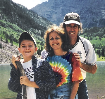 Kevin Neidorf as a kid with his parents in front of mountains.