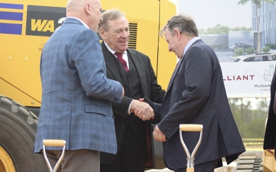Three men, FSU President Richard McCullough, U.S. Rep. Neal Dunn  and TMH President and CEO Mark O’Bryant, standing in front of construction equipment shaking hands